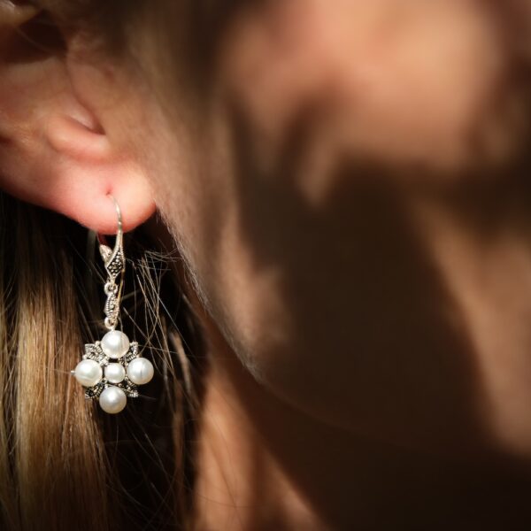 boucles d'oreilles pour femme avec perles valkyrie Paris portées sur l'oreille droite d'une mannequin blonde.