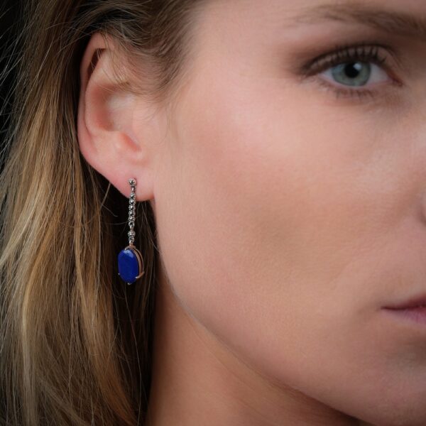 boucles d'oreilles en lapis lazuli et argent portées par une femme sur l'oreille droite de face.