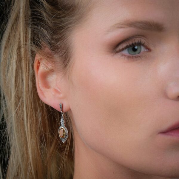 Boucles d'oreilles art déco pour femme sertis de quartz lemon portées sur l'oreille droite d'une femme.