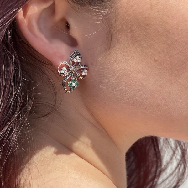 Boucles d'oreilles émeraude perles vintage portées sur l'oreille droite d'un mannequin.