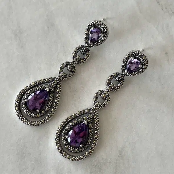 Valkyrie Paris earrings in marcasite and amethyst silver set on a grey background