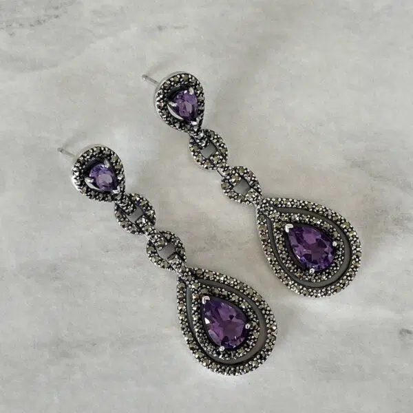 Valkyrie Paris earrings in marcasite and amethyst silver set on a grey background