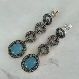 Vintage art deco blue jade pendant earrings set on a gray background.